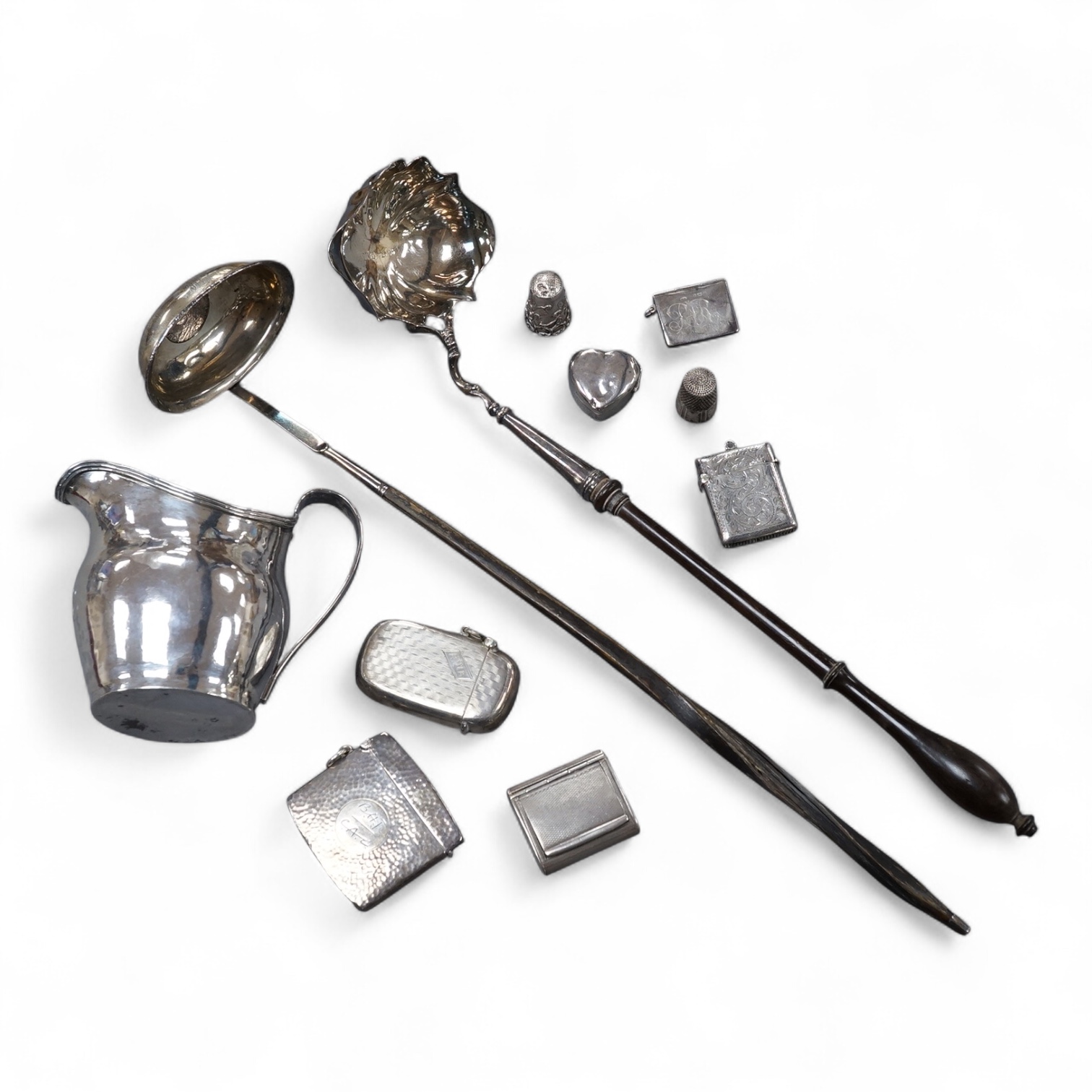 A small group of collectable silver including a George III silver cream jug, London, 1804, height 95mm, three silver vesta cases, two pill boxes, an envelope stamp case, two Georgian toddy ladles, one unmarked, together